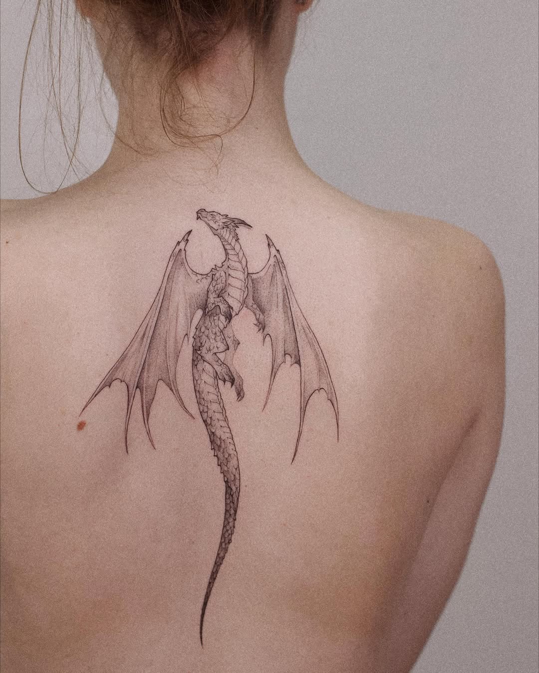 Intricate dragon tattoo scales along the spine