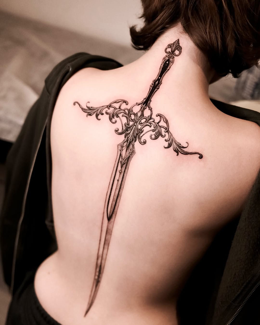 Intricate sword tattoo adorning the spine