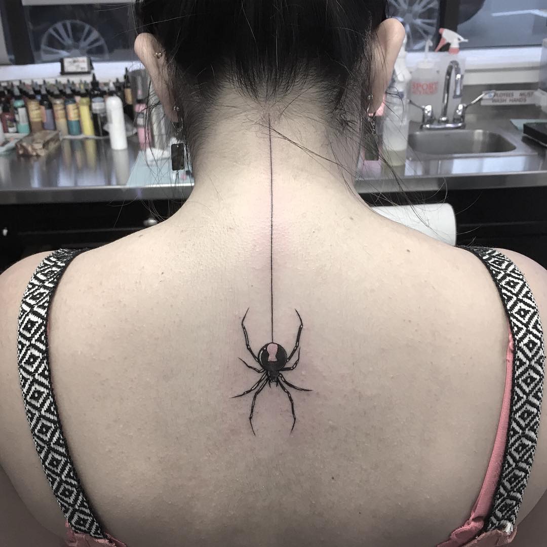 Bold spider tattoo running down the spine