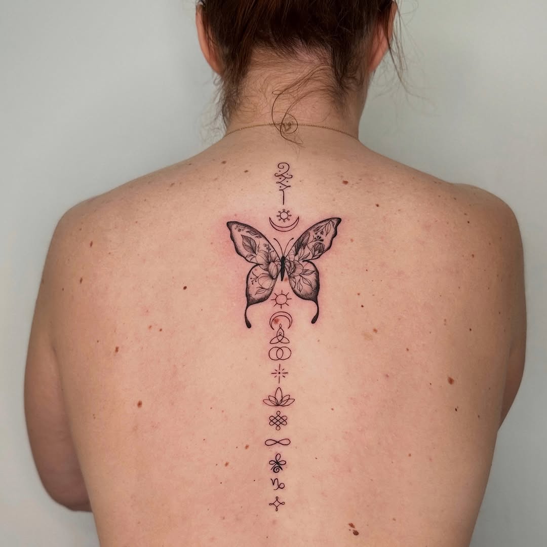 Elegant butterfly spine tattoo with symbolic details