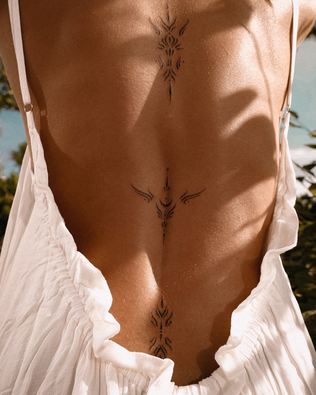 Elegant spine tattoo with tribal motifs