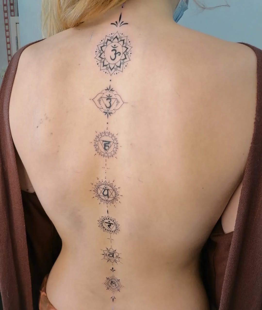 Elegant spine tattoo showcasing chakra symbols