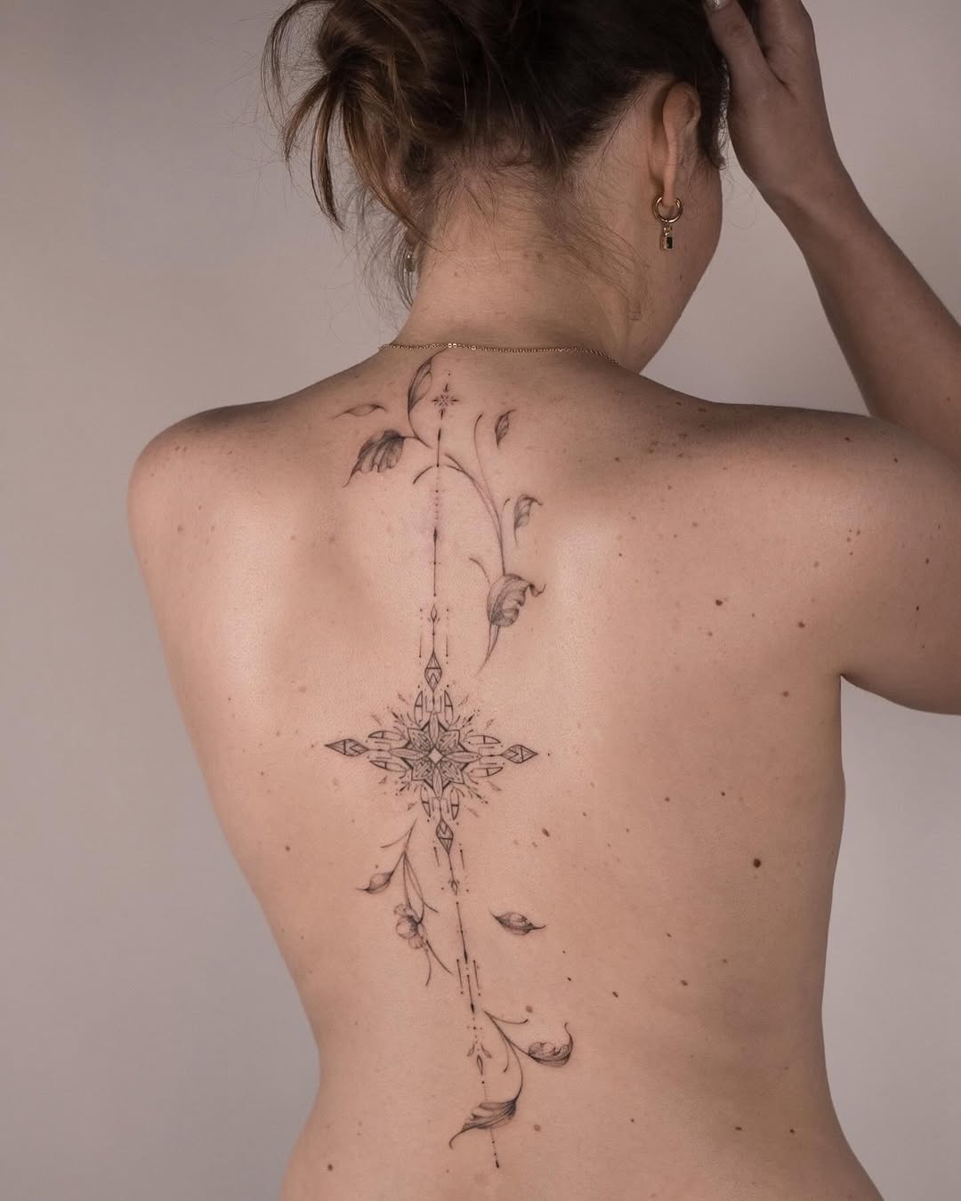 Delicate floral spine tattoo design with elegance