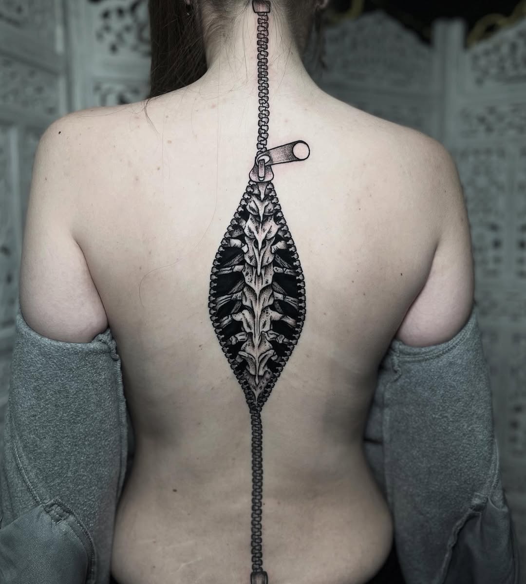 Intricate spine tattoo with zipper design