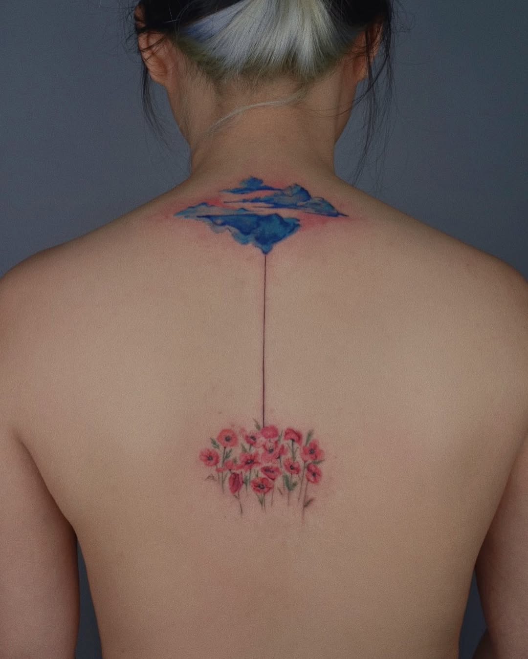 Vivid floral and cloud spine tattoo design