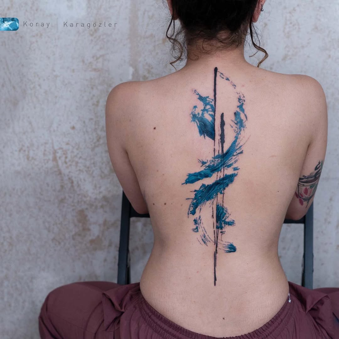 Striking color meets abstract spine tattoo design
