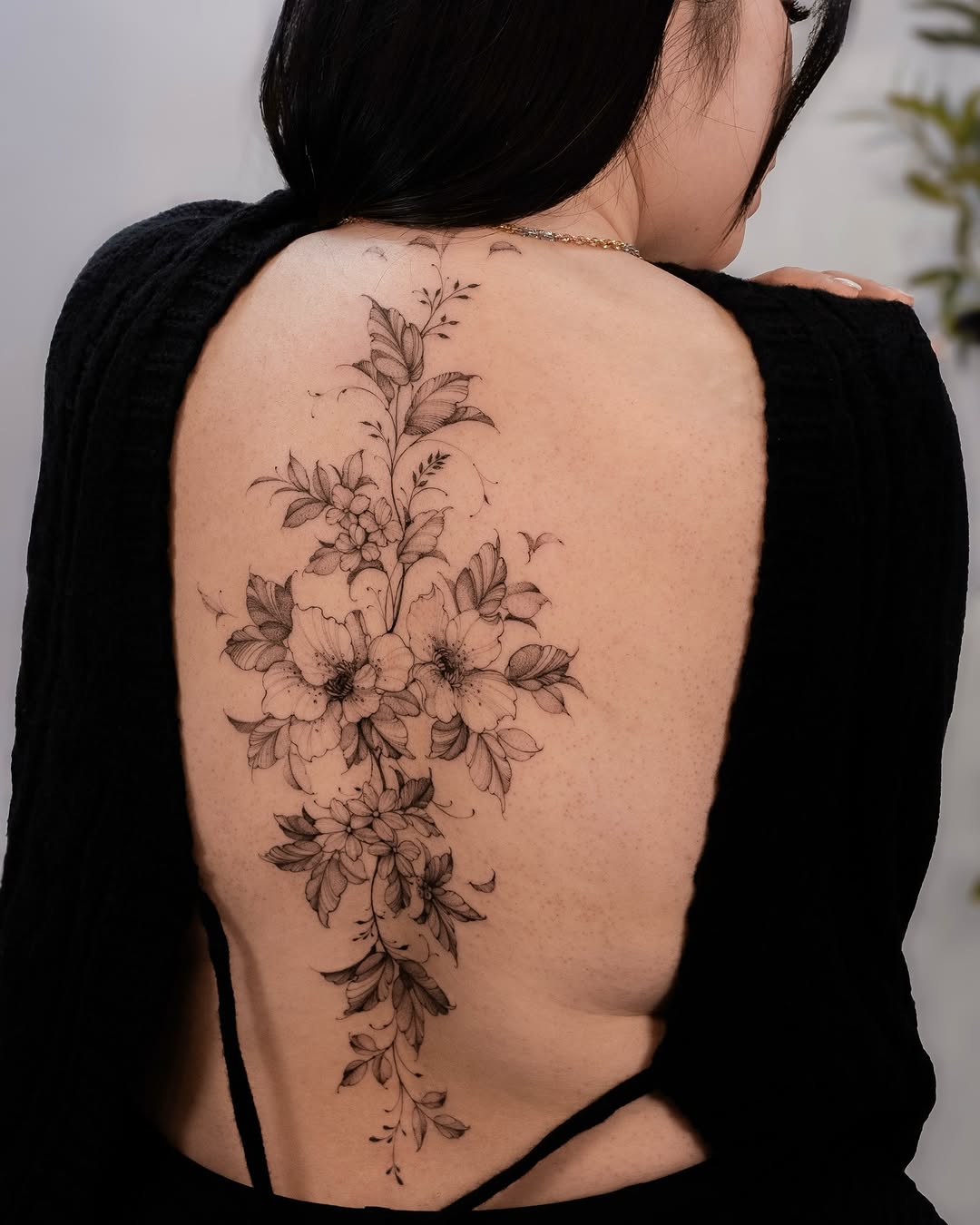 Exquisite floral spine tattoo with intricate detailing