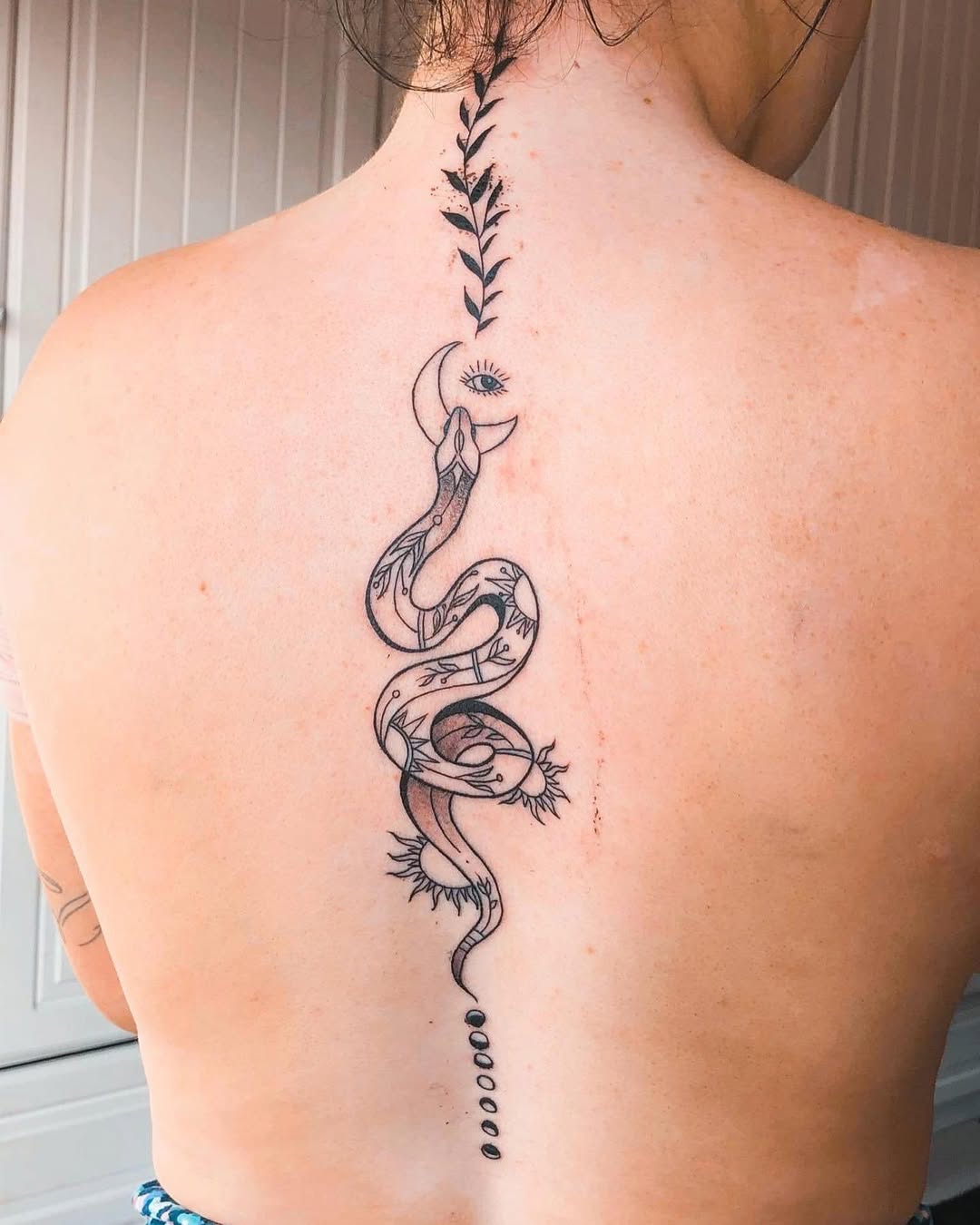Elegant snake tattoo along the spine