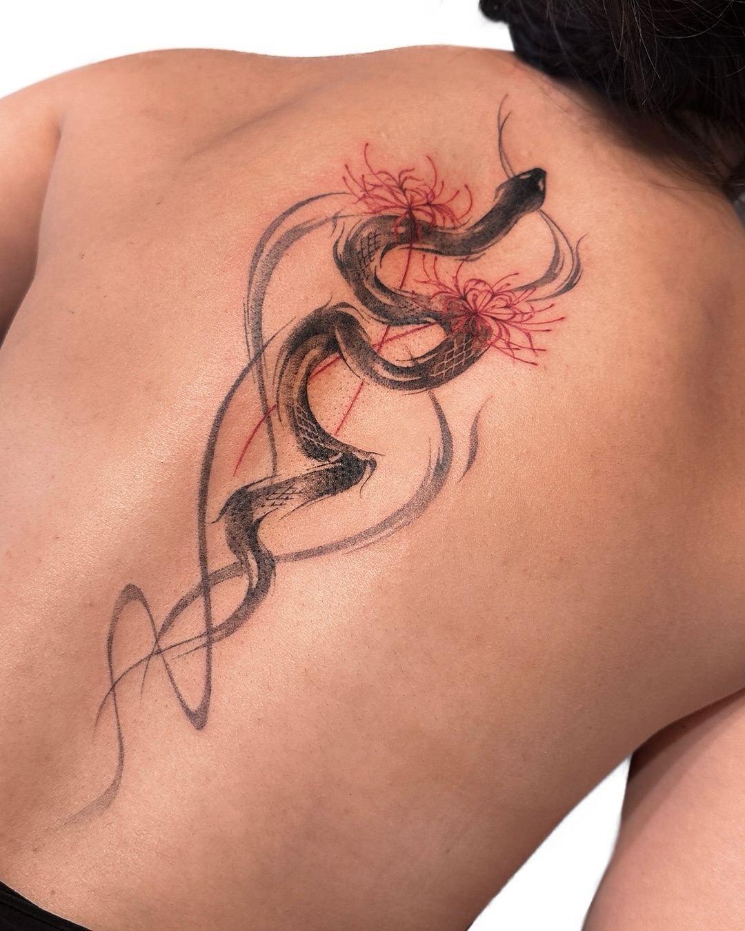 Elegant snake tattoo with floral accents