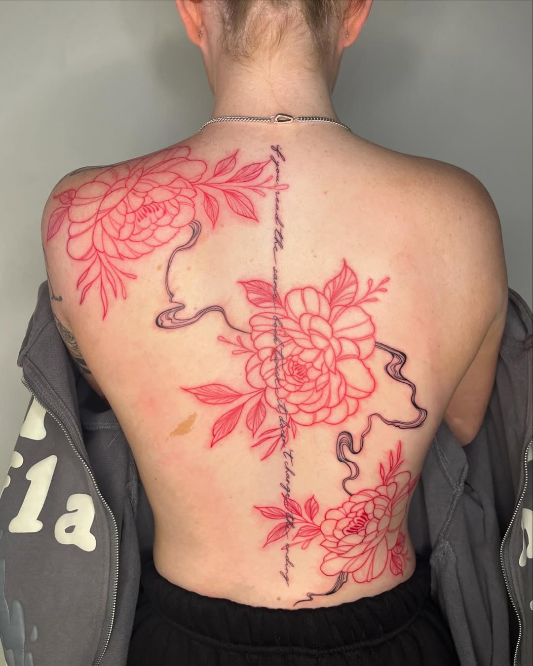 Elegant floral spine tattoo with delicate lines