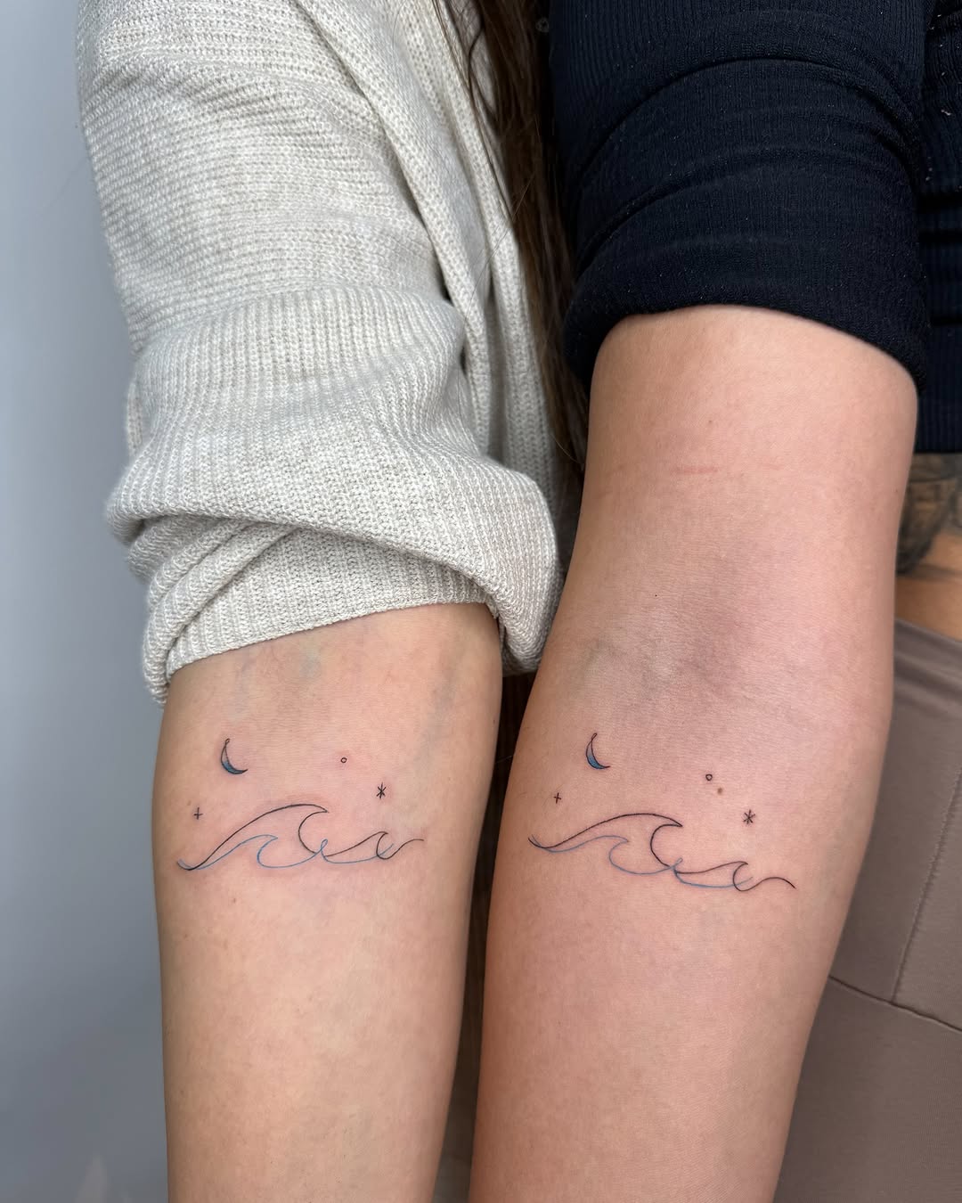 Elegant twin tattoos of waves and moons