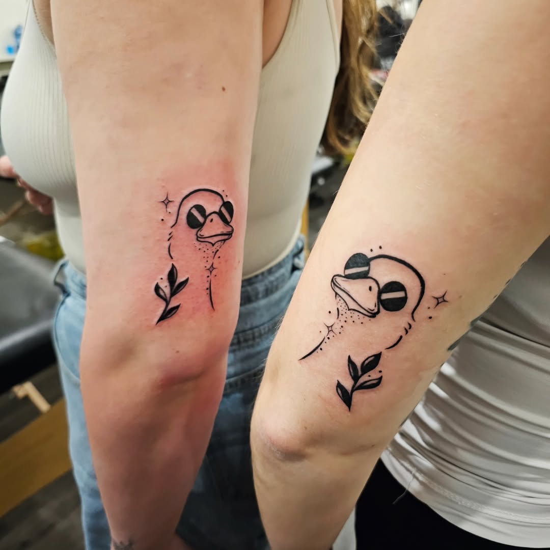 Charming matching duck tattoos for twins