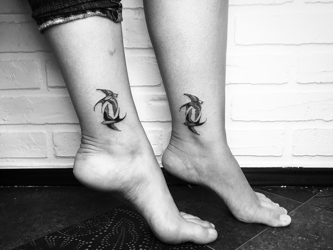 Symbolic twin bird tattoos on ankles