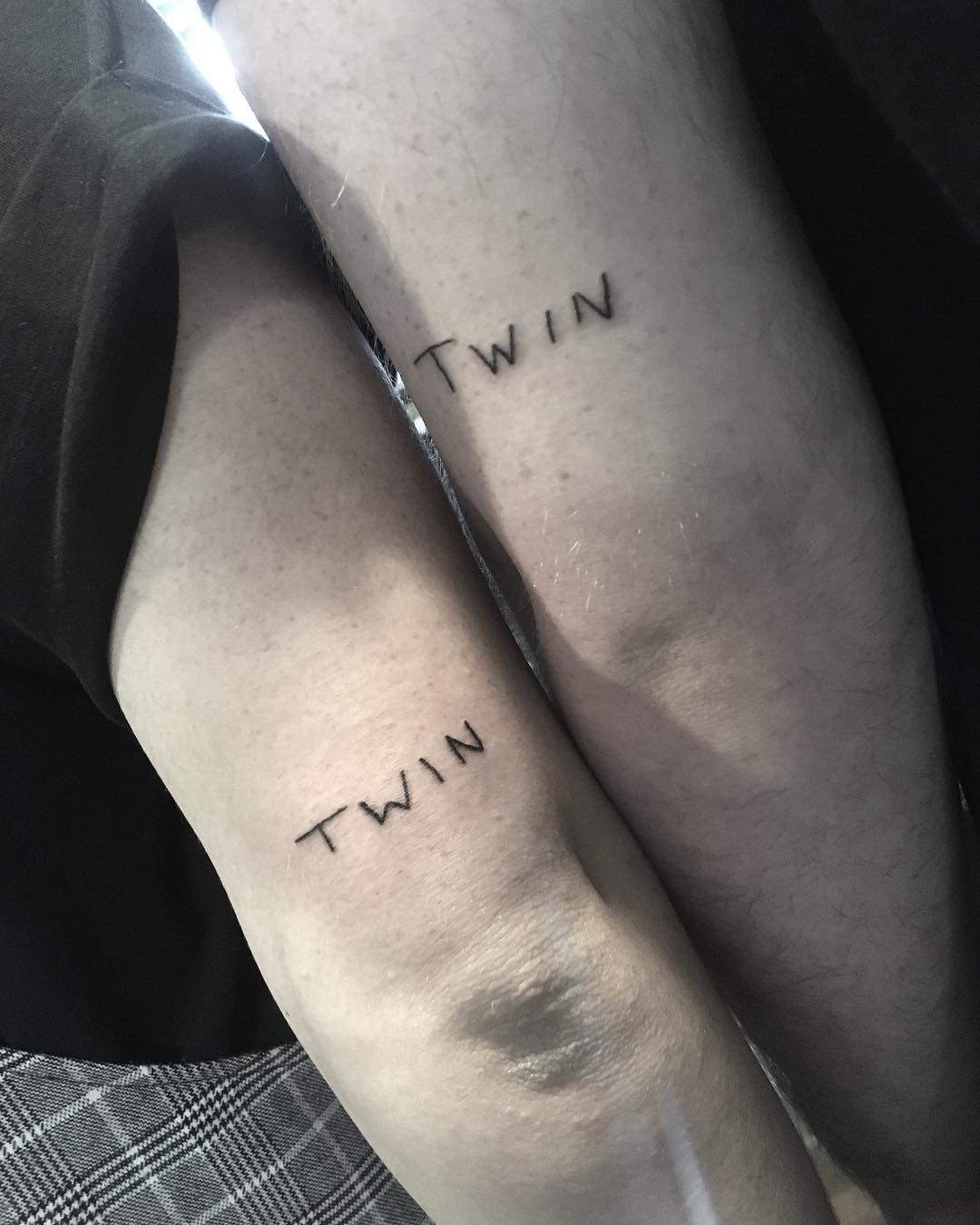 Minimalist twin tattoos in black ink