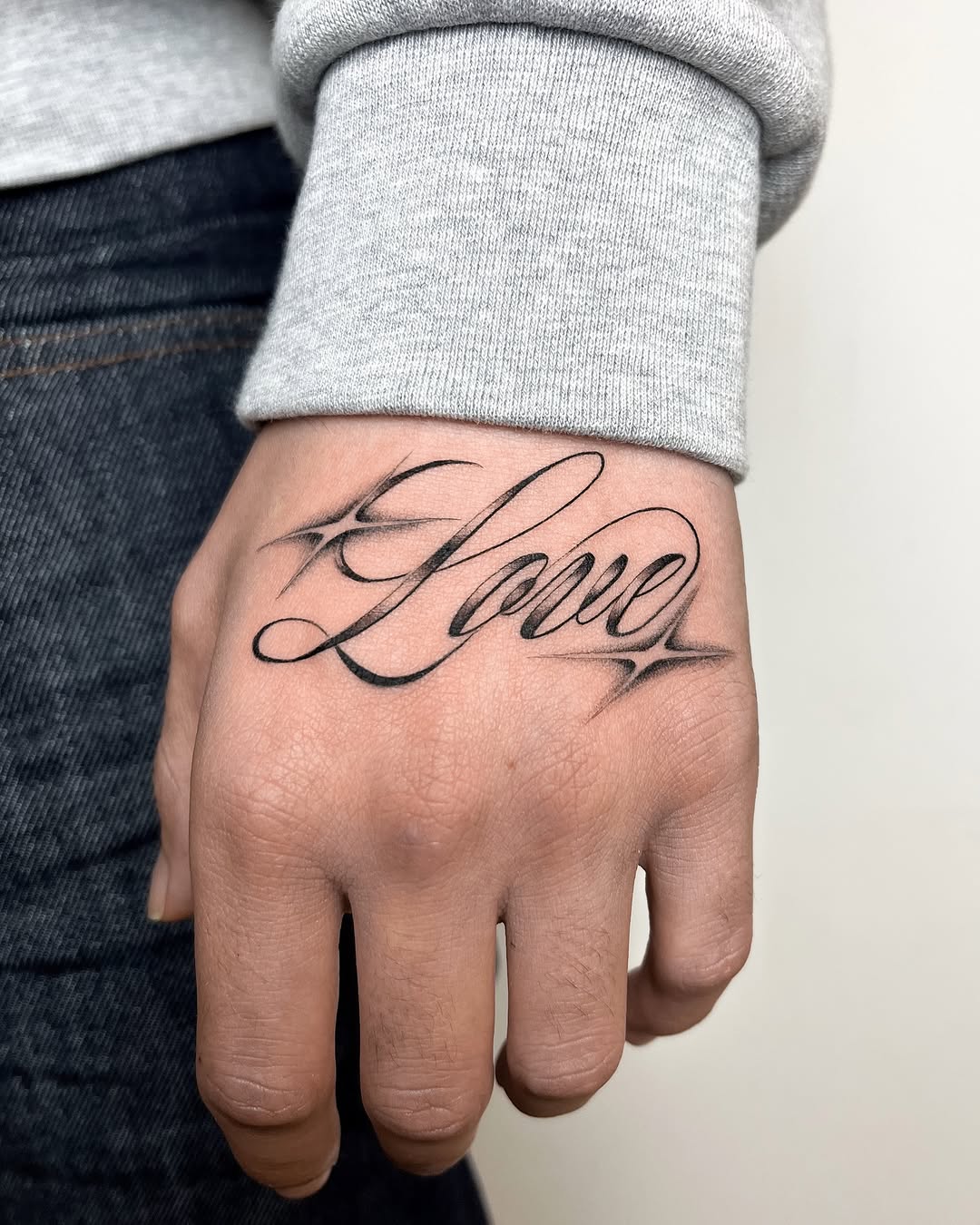 Elegant script tattoo of the word 'Love'