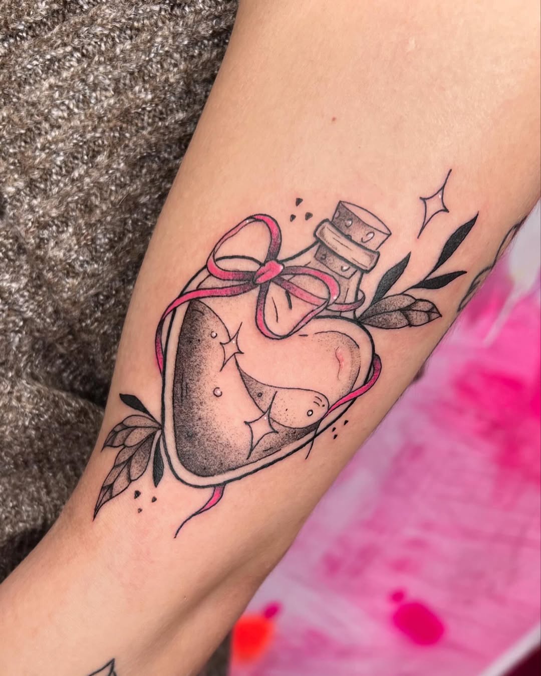 A charming heart-shaped potion bottle tattoo