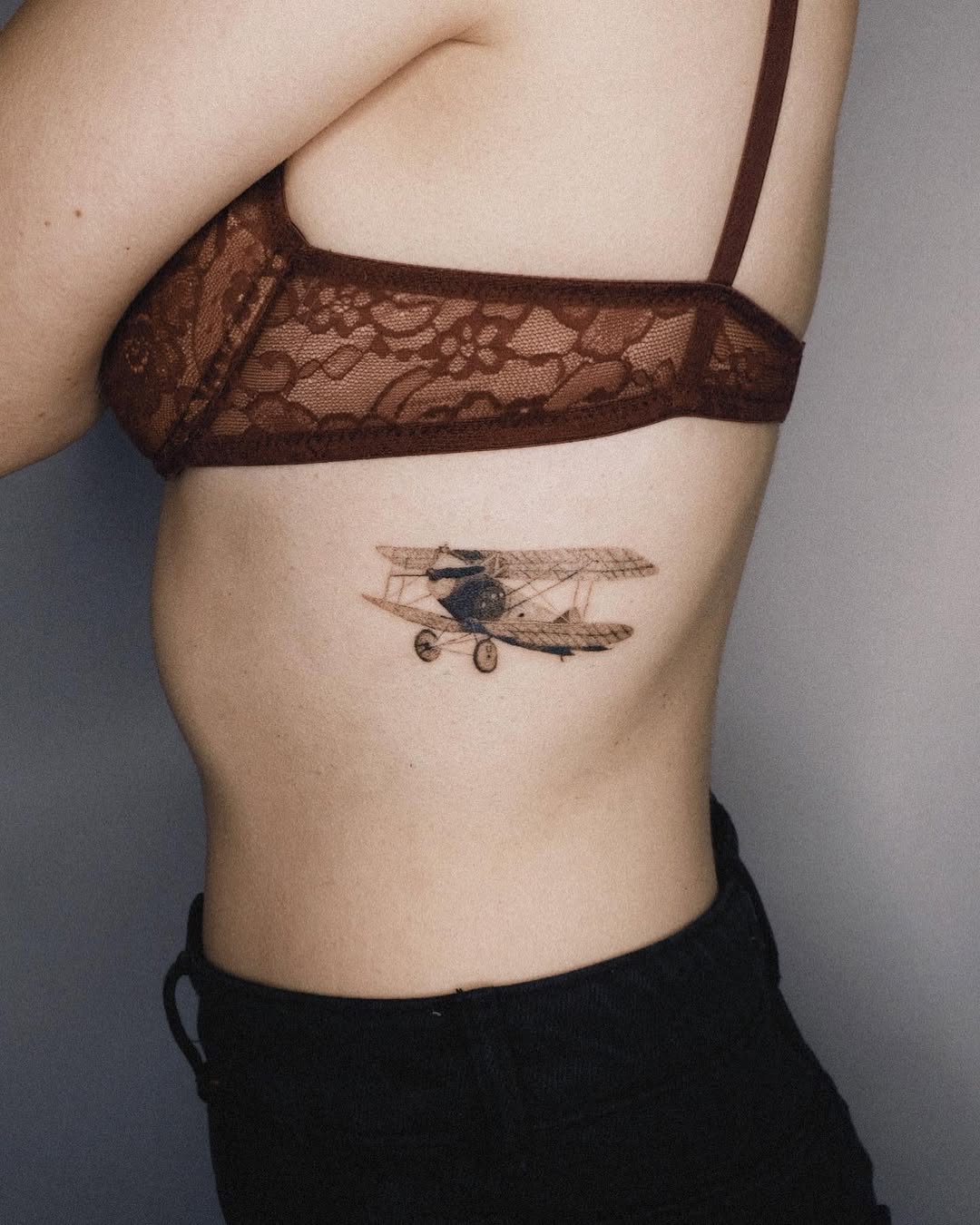 Elegant vintage airplane tattoo on the ribcage