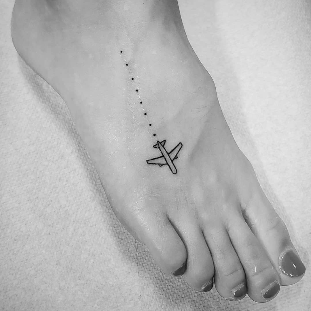 Minimalist airplane tattoo on foot