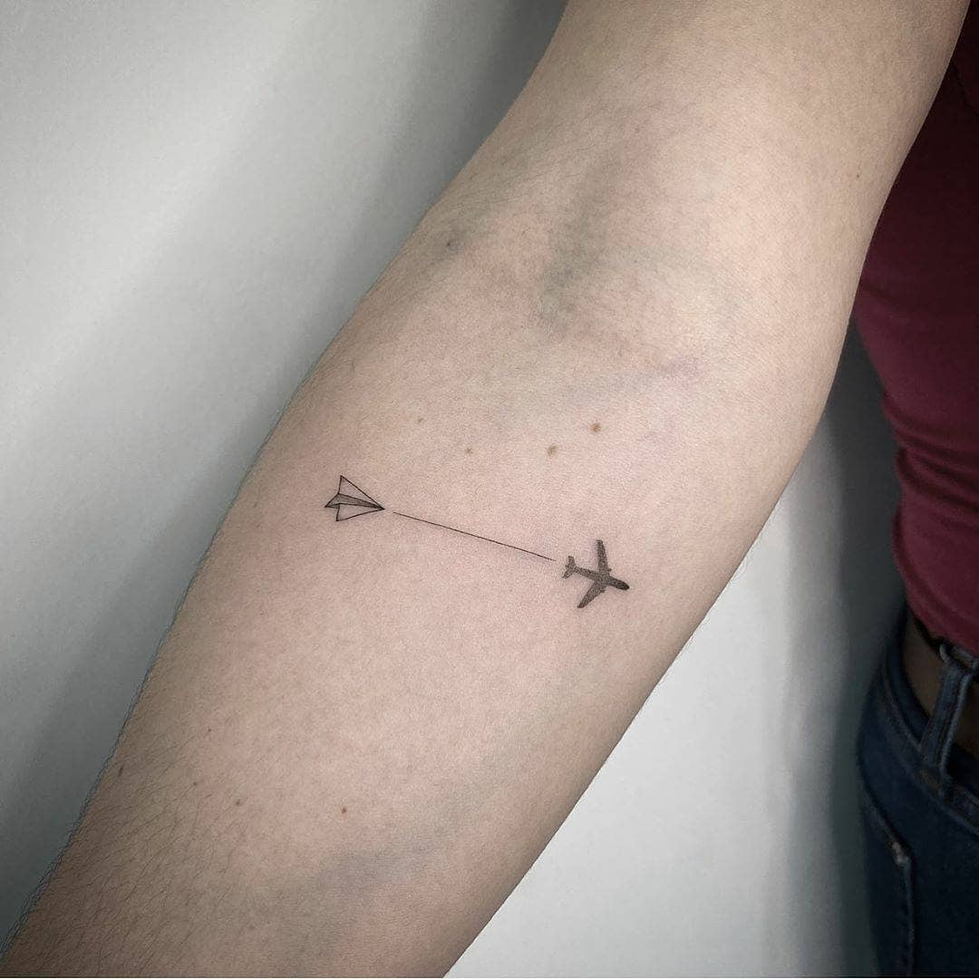 Minimalist airplane tattoo for travel enthusiasts