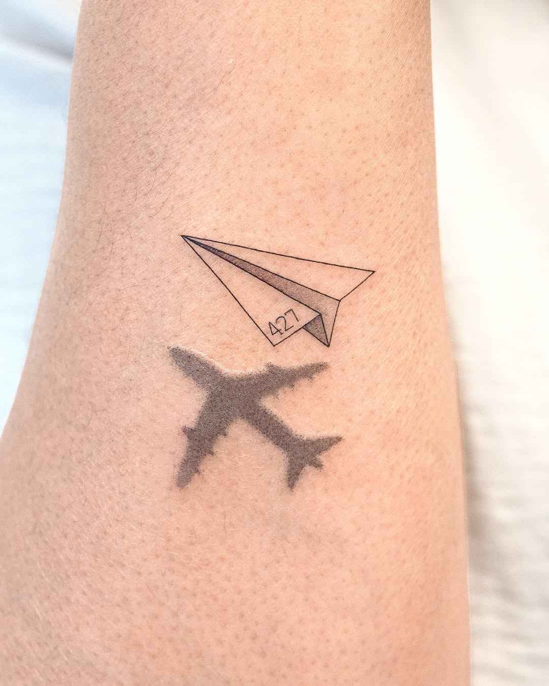 Unique airplane tattoo with paper plane design