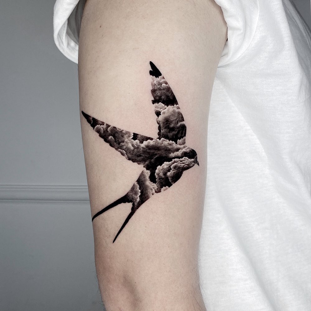 Stunning swallow tattoo with cloud design