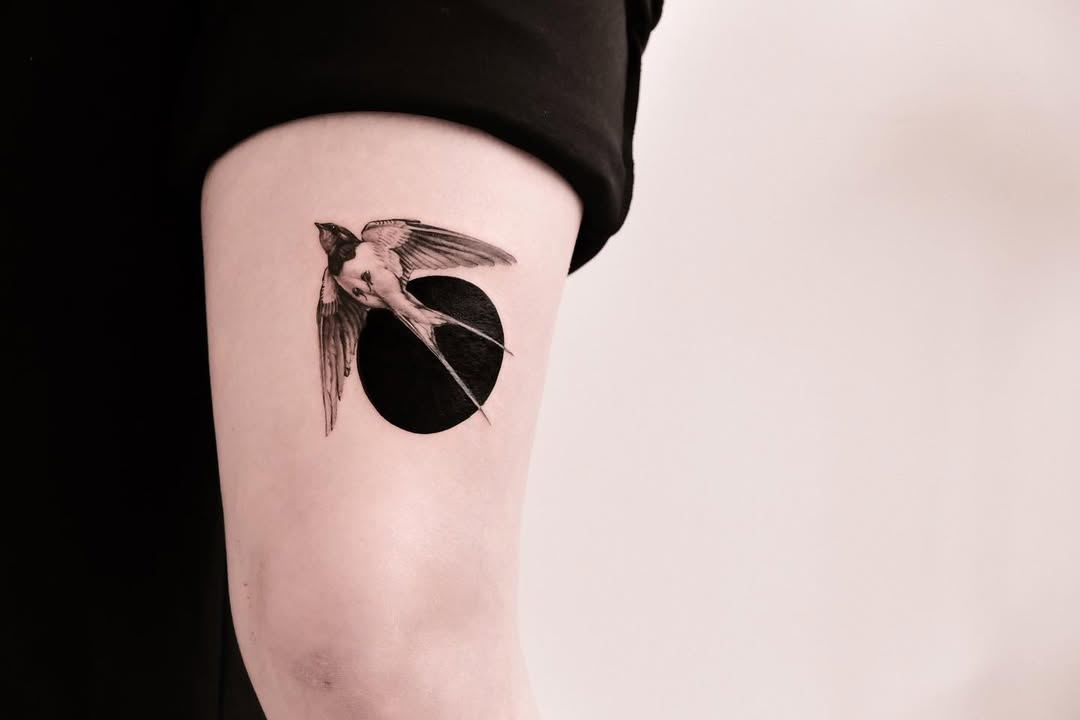 Stunning swallow tattoo against a dark backdrop