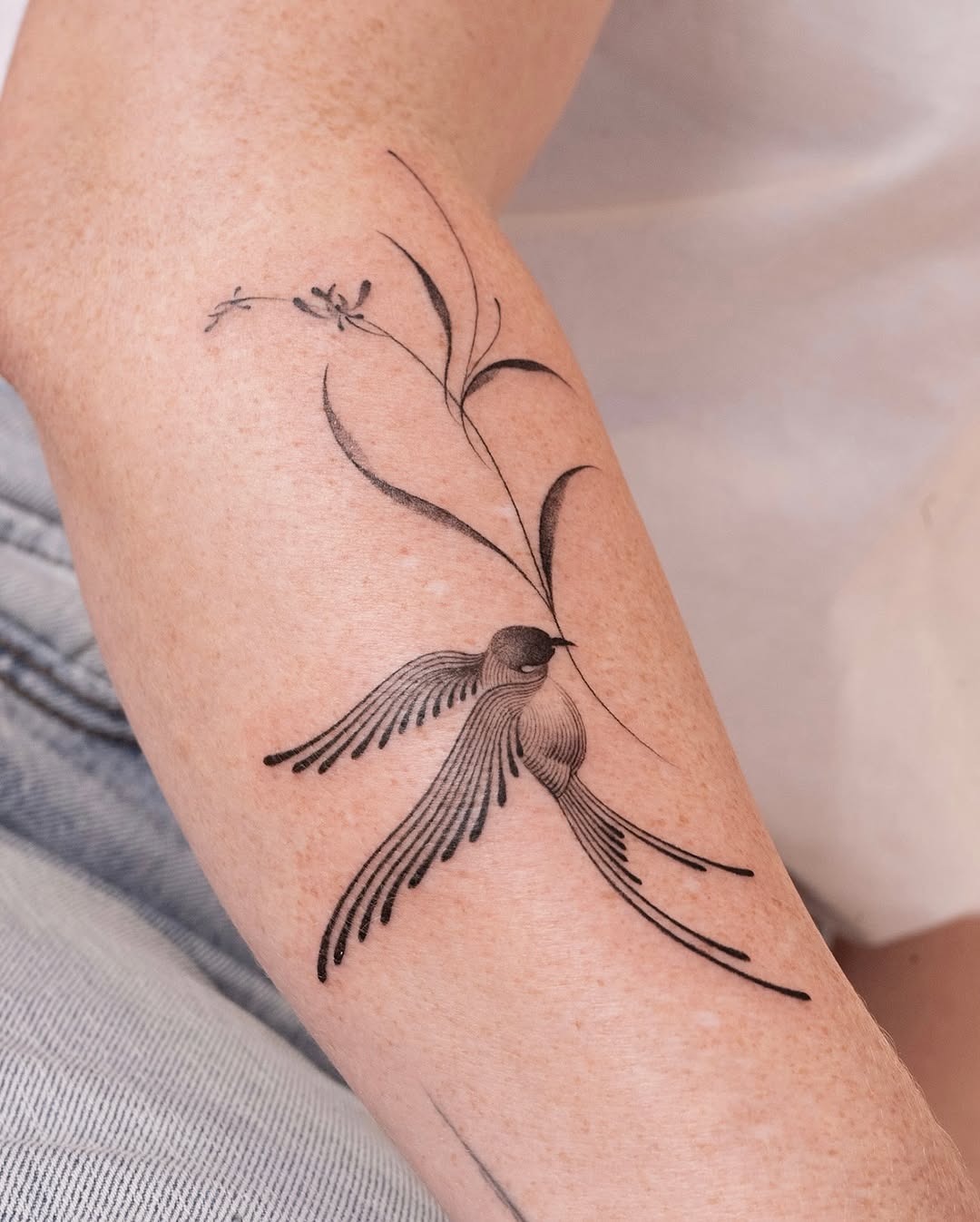 Elegant swallow tattoo with floral element