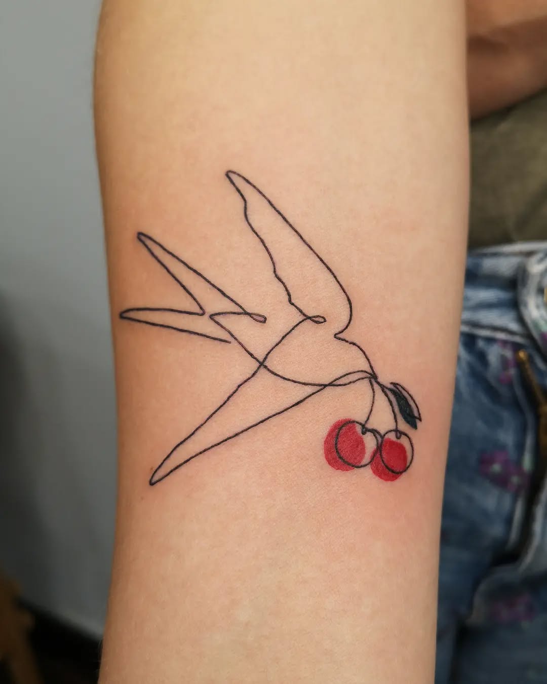 Charming swallow with cherry accents tattoo