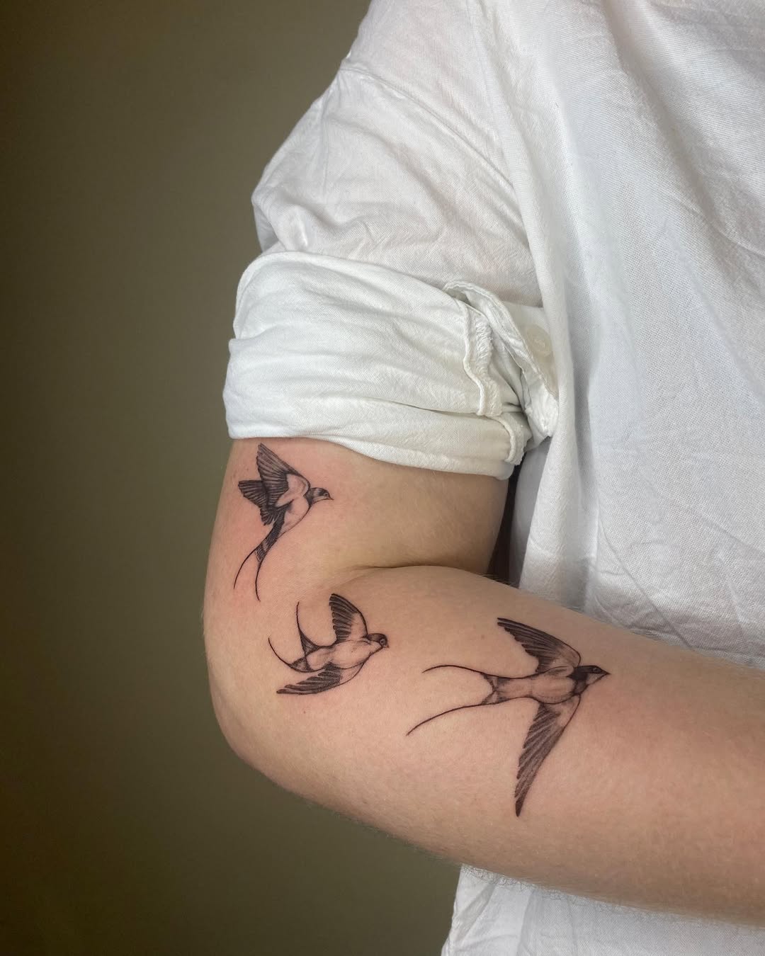 Elegant Swallow Tattoos on an Arm