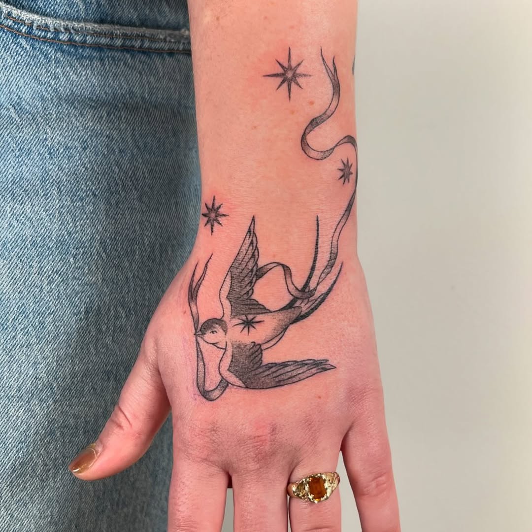 Elegant swallow tattoo with whimsical stars