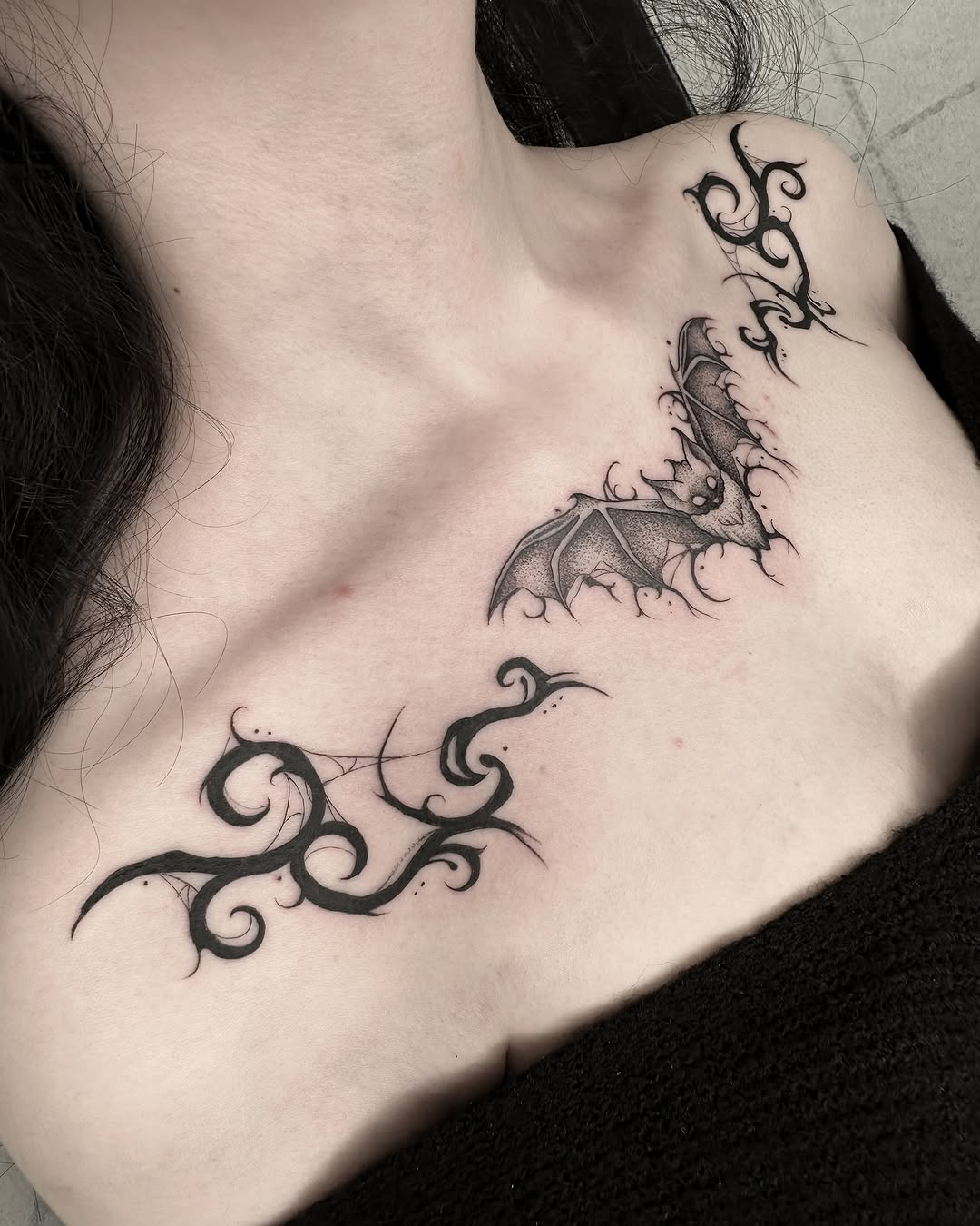 Striking bat and tribal chest tattoos