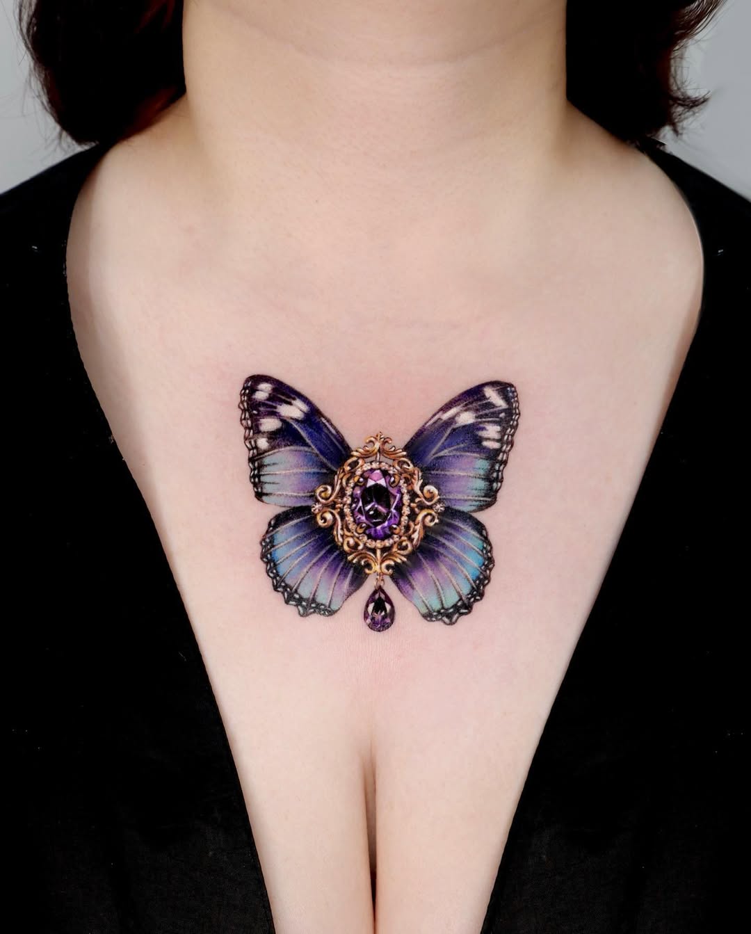 Elegant butterfly chest tattoo with gemstone details