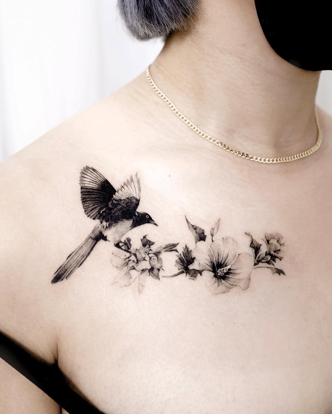 Intricate bird and floral chest tattoo design