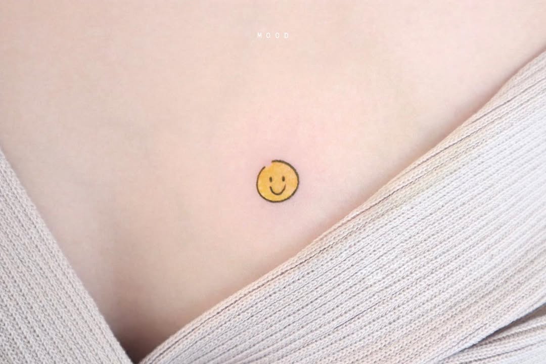 Minimalist smiley face chest tattoo design