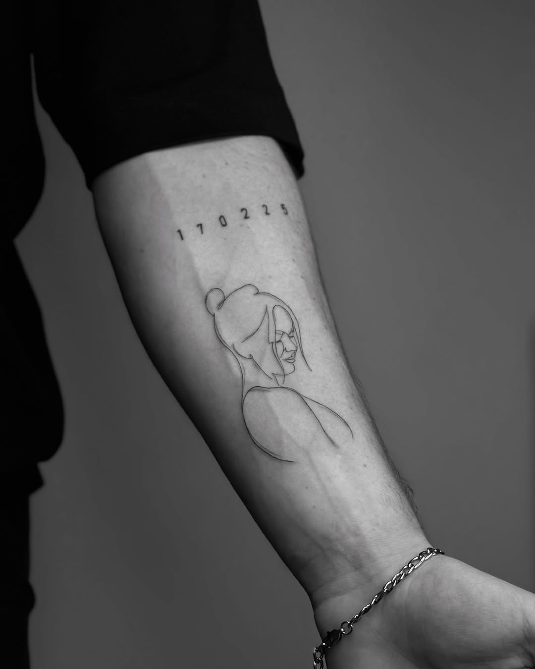 Elegant one-line portrait tattoo on forearm