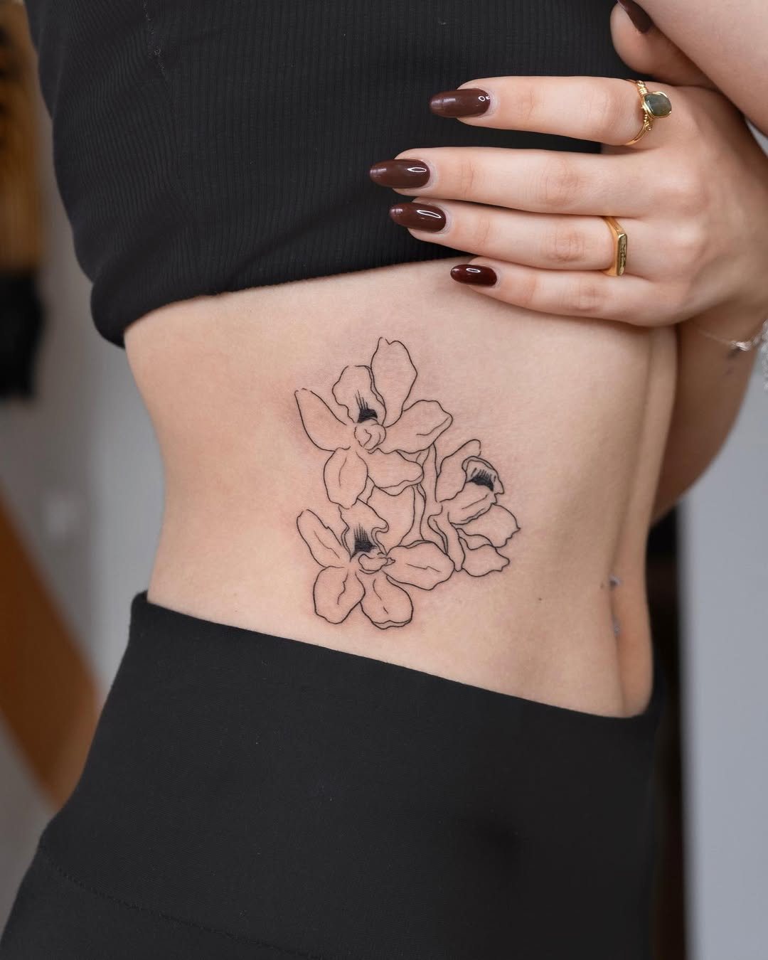 Elegant one line floral tattoo on the side.
