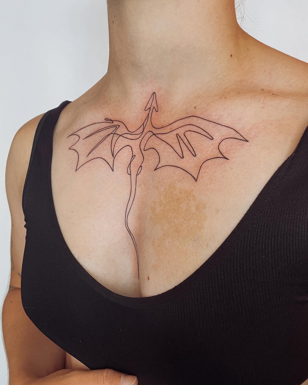 Elegant minimalist dragon tattoo design on chest