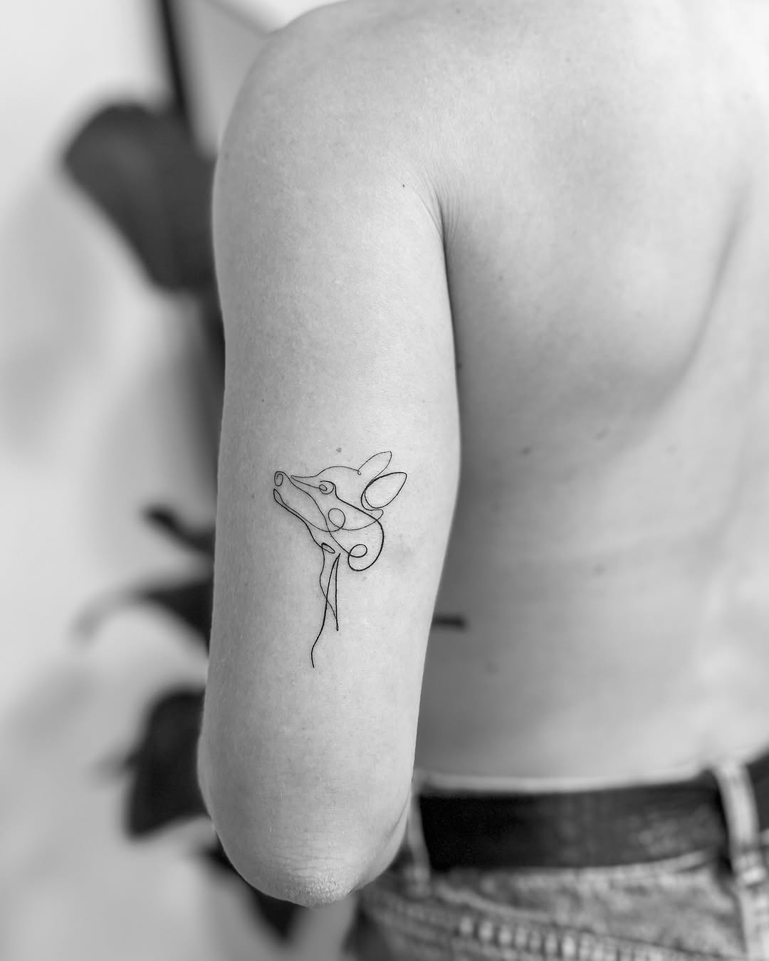 Minimalist tattoo showcasing a stylized animal face