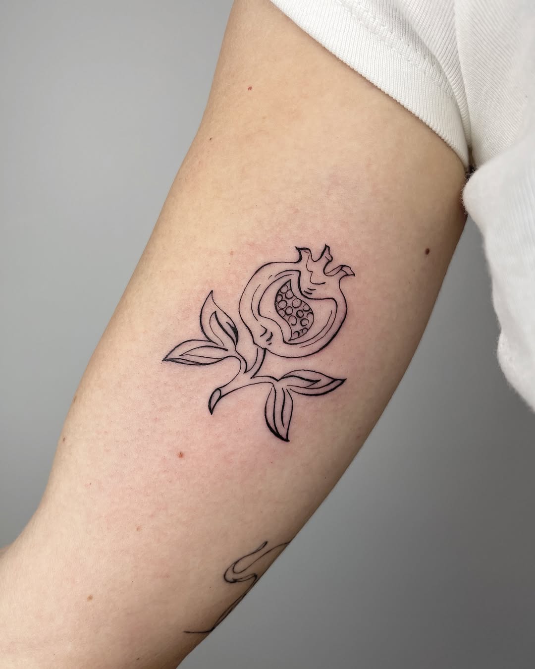 Elegant one-line pomegranate flower tattoo design