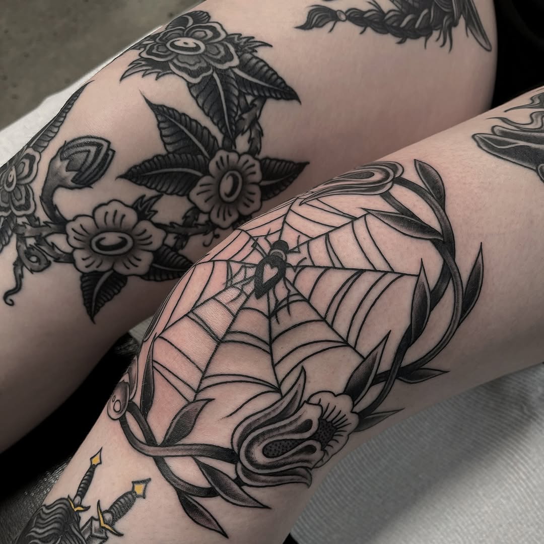 Intricate spider web knee tattoo design