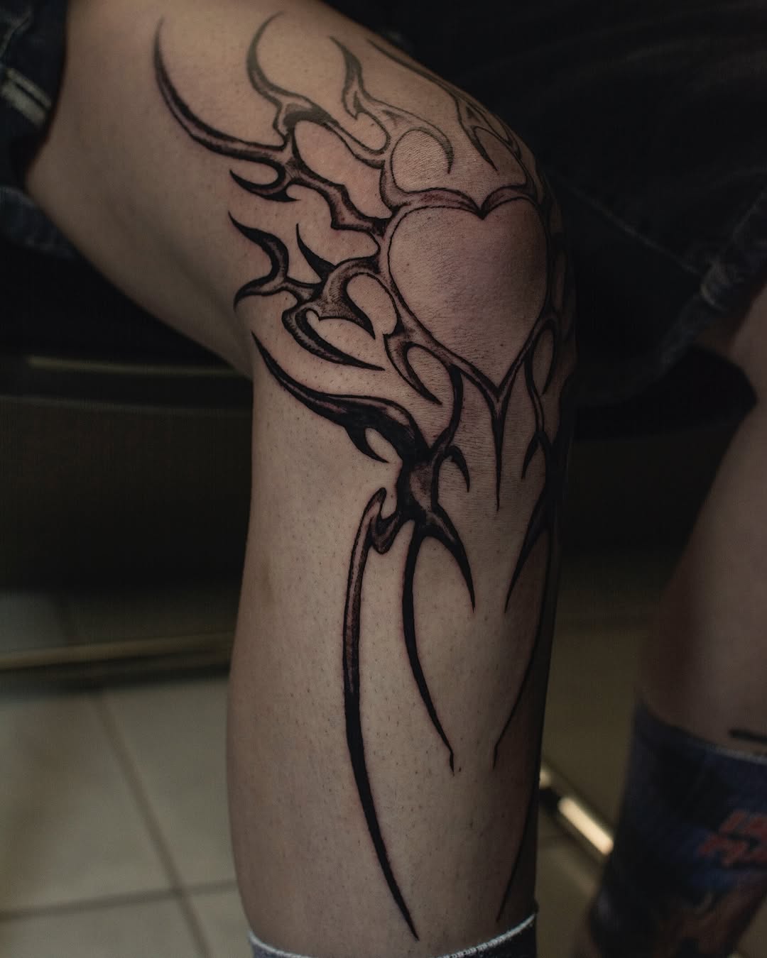 Striking tribal heart knee tattoo design