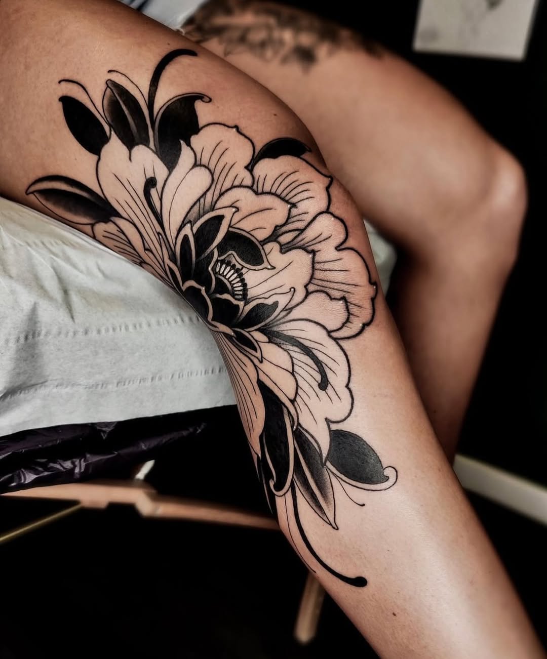 Stunning floral knee tattoo design featuring bold lines