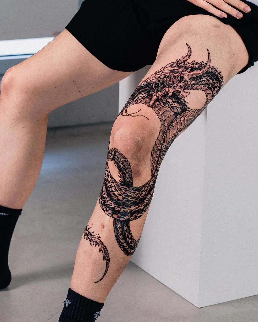 Stunning knee dragon tattoo design in black ink