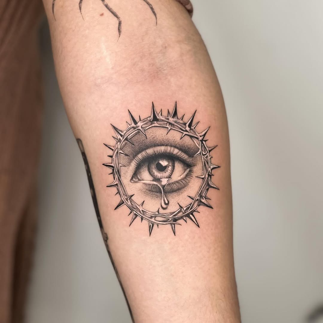 Intricate eye tattoo with thorny crown design