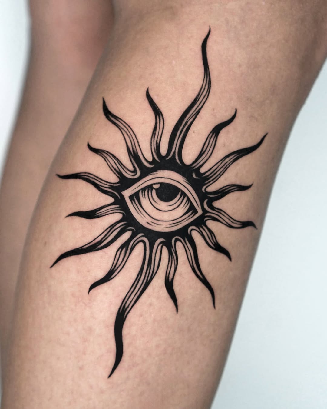 Stylish eye tattoo with sunburst elements