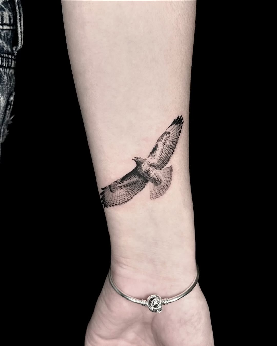 Intricate hawk tattoo in mid-flight pose.