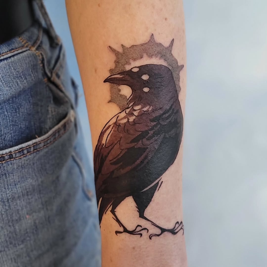 Stylish black crow tattoo with sunburst detail
