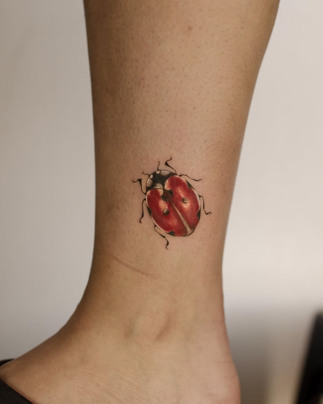 Vibrant Ladybug Tattoo on Ankle