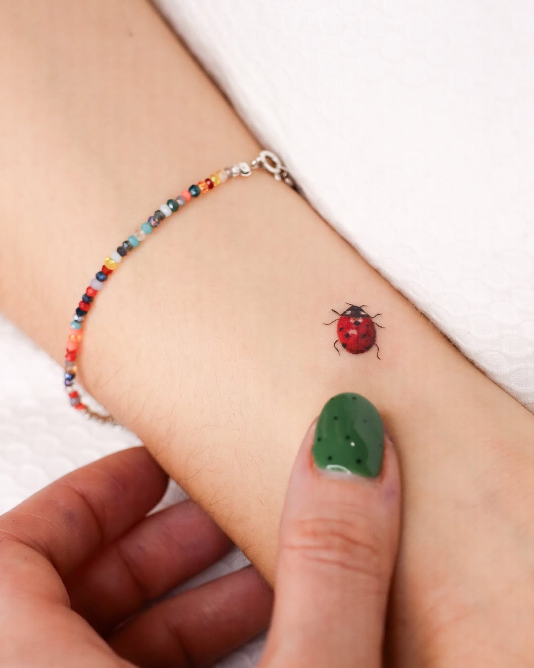 Charming ladybug tattoo on delicate wrist