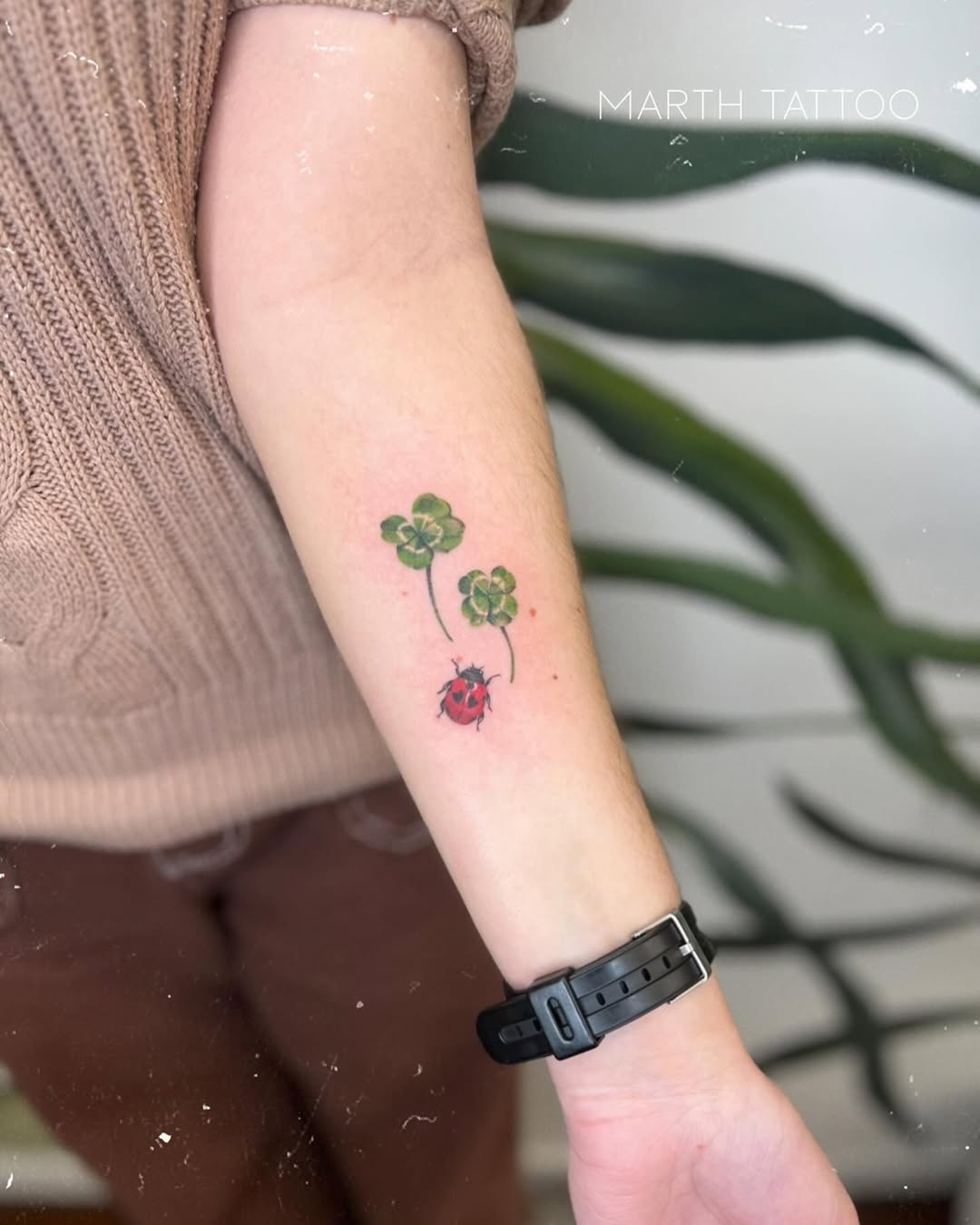 Charming ladybug and clover tattoo design